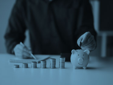 Businessman putting coins into piggy bank for saving money concept.
