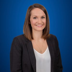 Melanie Tessarolo headshot with blue background